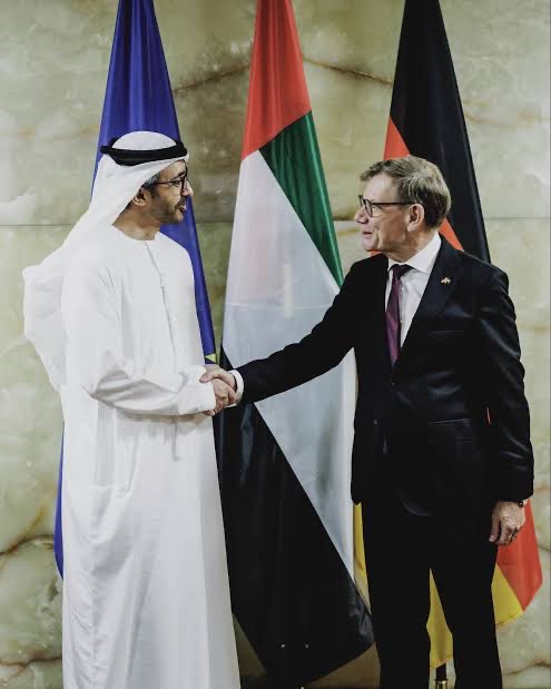 Johann Wadephul shaking hands with an Emirati counterpart in front of EU, UAE and German flags